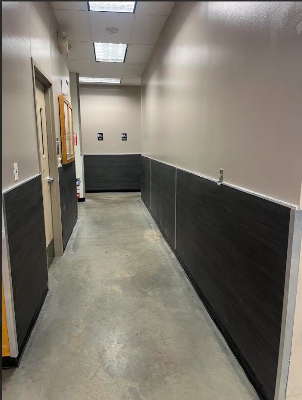 Completed back-of-house service corridor with wall protection paneling installed on both walls