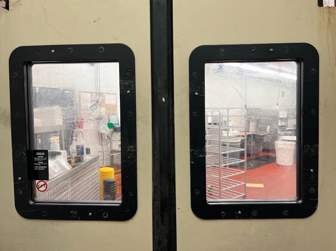 Insulated swing door window retrofit on grocery wet-prep area doors with new frames properly sealed