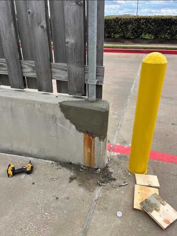 Loading dock concrete corner repair with new safety-yellow bollard install protecting rebuilt edge from future vehicle impact