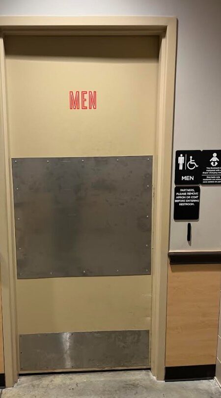 Men's restroom door with stainless steel armor plate and kick plate installed by FST