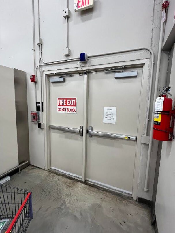 Panic exit hardware and hydraulic door closers installed on back-of-house fire exit doors, code-compliant life safety hardware