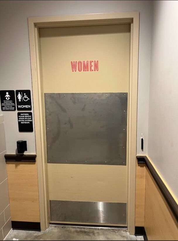 Women's restroom door with stainless steel armor plate and kick plate hardware